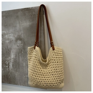 Detail of crochet tote bag showing cream mesh texture and brown faux leather strap
