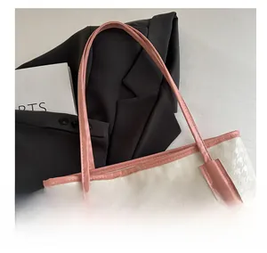 Gros plan des poignées roses et du relief pied-de-poule sur le grand sac cabas bicolore