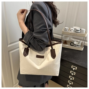 Détail du sac cabas en toile avec garniture en cuir marron et étiquette Fashion & Bags