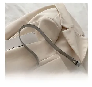 Detail of grey bow-decor underarm bag with shimmering texture and leather strap