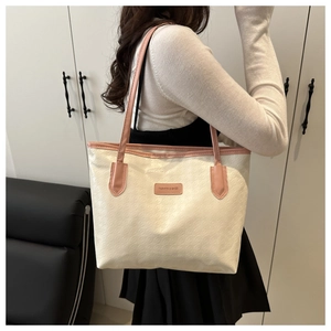 Détail des coutures et bordures en cuir rose sur un grand sac cabas crème élégant