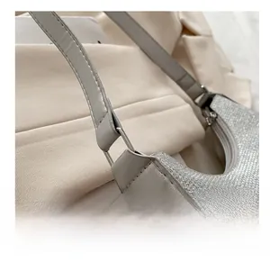 Detail of silver sequin bag showing the metallic ring connection between strap and body