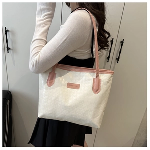Détail du sac cabas blanc avec anses roses et texture géométrique gaufrée sur modèle