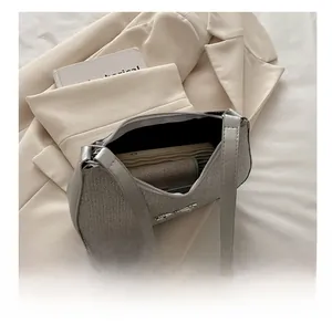 Internal capacity of silver woven shoulder bag showing smartphone and card holder