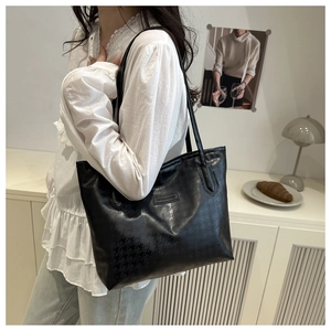 Détail du sac cabas noir avec gaufrage pied-de-poule et étiquette en cuir chic