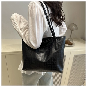 Détail d'un grand sac fourre-tout noir avec motif pied-de-poule et étiquette de mode
