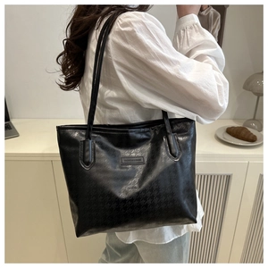 Détail du sac cabas en cuir PU noir avec gaufrage pied-de-poule et étiquette tendance