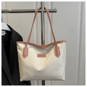 Détail du cabas blanc cassé avec motif pied-de-poule et étiquette de mode en cuir rose