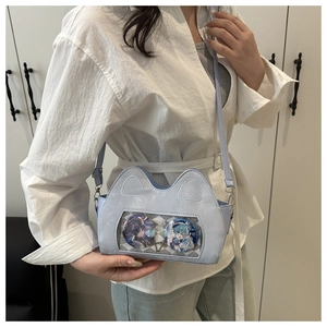 Detail of light blue cat-ear ita bag showing a clear window with decorative anime badges