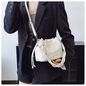 Detailed view of off-white cloud bucket bag with woven handle and gold-tone hardware