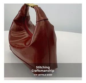 Detailed stitching and metallic clasp on burgundy vintage faux leather crescent bag