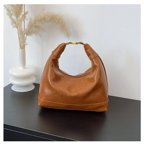 Detail of brown hobo bag with embossed qaoins logo and golden buckle on handle