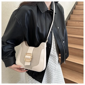 Détail d'un sac bandoulière vintage en toile et cuir PU avec boucle dorée élégante