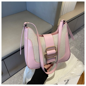 Detail of pink PU leather and canvas patchwork bag with golden metal buckle and strap