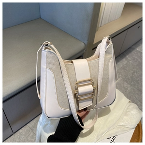 Detail of cream white leather and textured woven shoulder bag with gold metal buckle