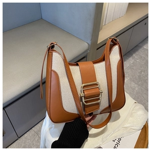 Detail of retro patchwork hobo bag with brown leather, canvas and gold metal buckles
