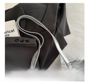 Detail of silver tote bag handle and butterfly print with chic lifestyle styling