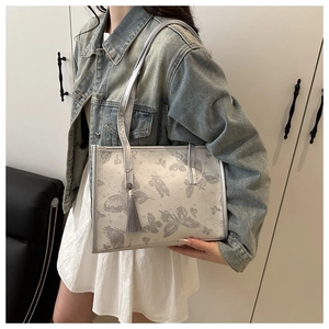 Silver-grey tote bag with butterfly pattern prints and stylish tassel charm detail
