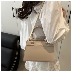 Detail of beige PU leather bag with Fashion Trend lettering and gold hardware accents