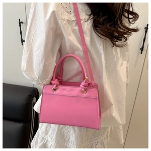 Pink PU leather tote bag with FASHION TREND lettering worn by a model in a modern room