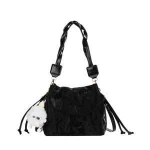 Minimalist black drawstring bucket bag with velvet texture and plush ball charm