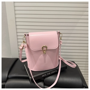 Close-up of pink bucket bag featuring a gold metal lock and fine leather texture