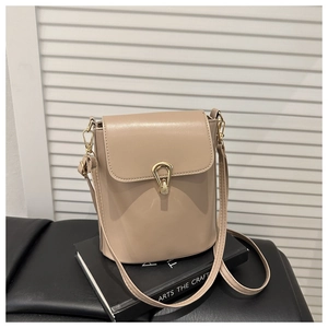 Detail view of the beige bucket bag with gold-colored teardrop-shaped metal twist lock