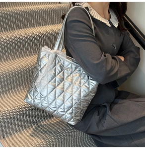 Détail du sac cabas matelassé argenté avec nœud en dentelle et accents métalliques