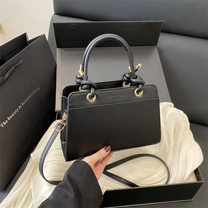 Large black minimalist tote bag with knot handles and fashion trend embossed detail
