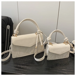 Detailed comparison of large and mini white leather handbags with elegant knot handles