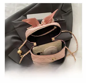Detailed interior view of pink quilted bag showing storage for phone and cosmetics