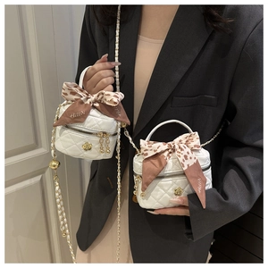 Comparison of small and large white quilted mini bags with silk ribbon and chain straps