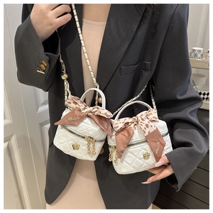 Détail du mini sac blanc matelassé avec fermoir fleur en métal et nœud en soie imprimé