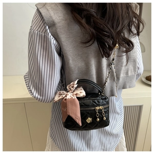 Mini sac seau matelassé avec poignée foulard et détails dorés porté au dos