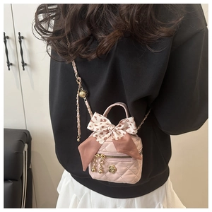 Detail of pink bucket bag with quilted stitching, golden camellia and polka dot bow