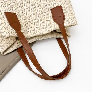 Detailed close-up of woven straw texture and reinforced brown faux leather handles