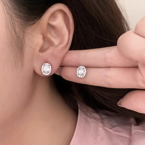Elegant sterling silver halo stud earrings featuring oval-cut white cubic zirconia