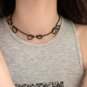 Elegant black beaded choker featuring three woven bow designs and gold accent beads