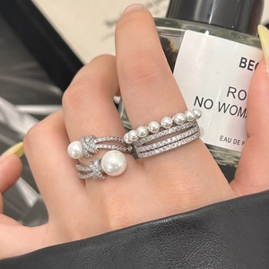 Bagues minimalistes en argent avec perles et zircons portées par une femme élégante