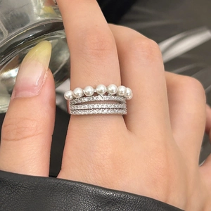 Vue détaillée d'une bague argentée ornée de trois rangs de zircons et sept perles blanches