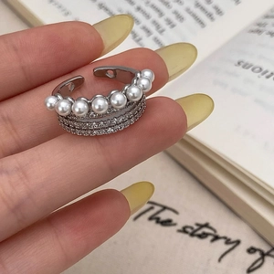Détail d'une bague triple épaisseur avec perles blanches et zircons scintillants