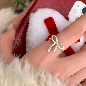 Elegant gold bow ring with sparkling zircon pavé and delicate hanging pearl tassels