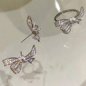 Luxury zircon bow jewelry set including adjustable ring and stud earrings on bright surface