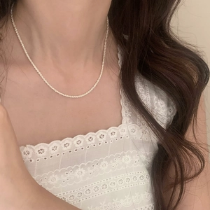 Élégant collier ras du cou étoilé scintillant en finition dorée porté par un modèle sur dentelle