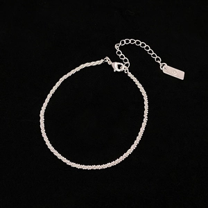 Détail d'un collier à chaîne argentée torsadée avec fermoir mousqueton et maillon réglable