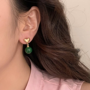Elegant gold heart earrings with dark green chalcedony beads shown on female model