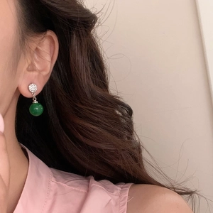 Gros plan de boucles d'oreilles rétro avec perle vert émeraude et métal martelé argenté