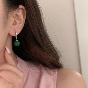 Gros plan de boucles d'oreilles vintage en argent avec pendentif en calcédoine verte