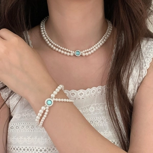 Détail d'un ensemble de collier et bracelet en perles avec pierres bleu ciel