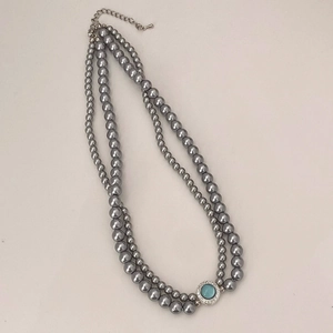 Vue détaillée du collier double rang en perles grises avec pendentif vintage en cristal